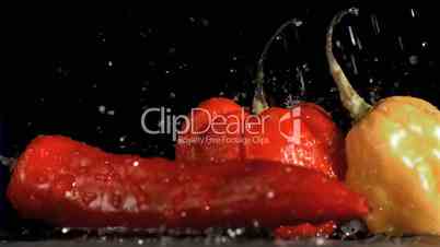 Drops in super slow motion falling on spicy vegetables
