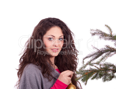 Junge Frau mit dunklen Haaren dekoriert einen Weihnachtsbaum