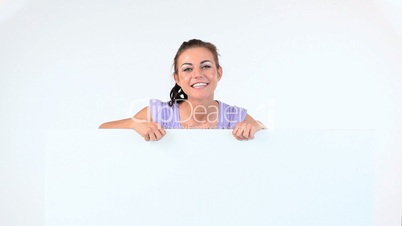 Young woman smiling while she is pointing something on a board