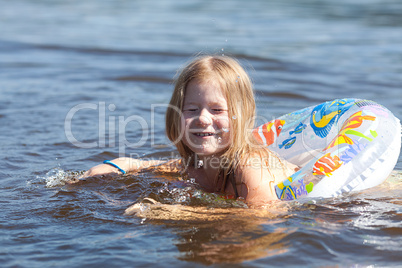 portrait of a beautiful little girl with a color lifebuoy