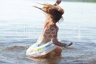 beautiful little girl splashes in the water