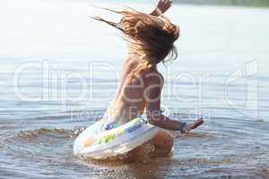 beautiful little girl splashes in the water