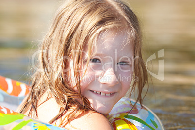 portrait of a beautiful little girl with a color lifebuoy