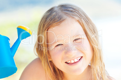 portrait of a beautiful little girl with a watering can