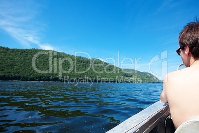man in a boat on the background of the river and mountains