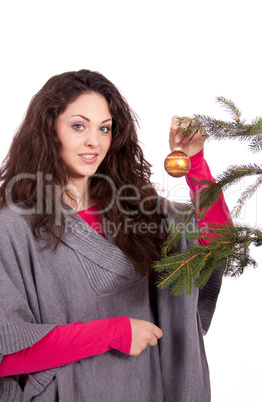 Junge Frau mit dunklen Haaren dekoriert einen Weihnachtsbaum