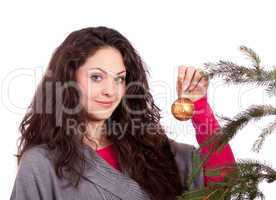Junge Frau mit dunklen Haaren dekoriert einen Weihnachtsbaum