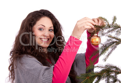 Junge Frau mit dunklen Haaren dekoriert einen Weihnachtsbaum