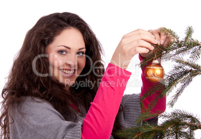 Junge Frau mit dunklen Haaren dekoriert einen Weihnachtsbaum