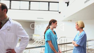 Doctor holding a clipboard next to nurses