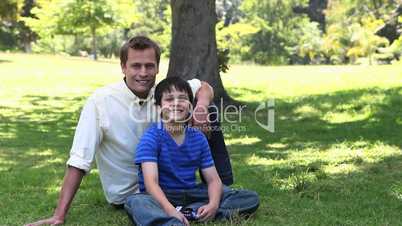 Father and his child sitting in a park