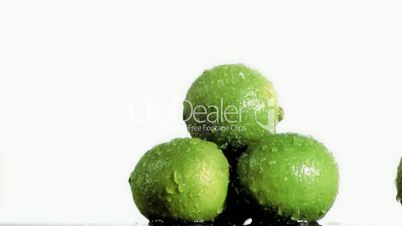 Three delicious limes in super slow motion being soaked