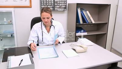 Doctor writing on a notepad at his desk