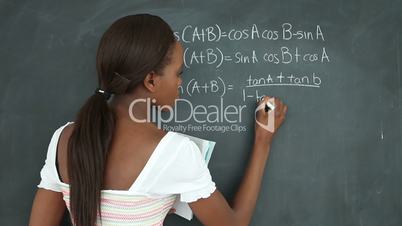 Video of a black student writing on a blackboard