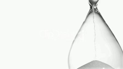 Sand in super slow motion falling from a hourglass