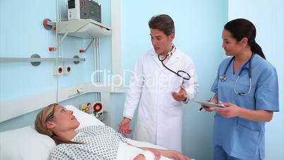 Doctor auscultating a patient next to a nurse