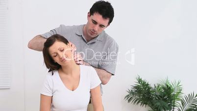 Physiotherapist massaging the neck of a woman