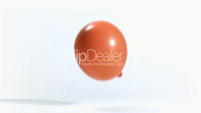 Orange balloon rebounding in super slow motion