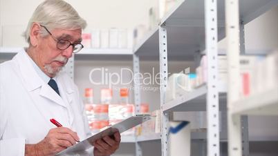 Pharmacist looking at pills in a shelf