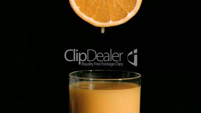 Orange drop falling in super slow motion in a glass