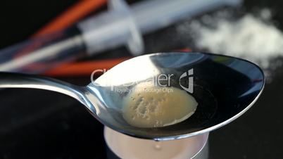 Heroin in a spoon being heated by a tea light