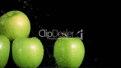 Green apples watering in super slow motion