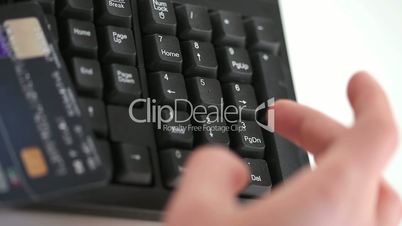 Somebody typing on a keyboard with a credit card