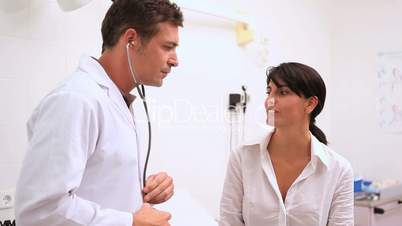 Doctor holding a stethoscope with a patient