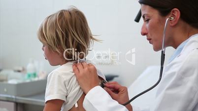 Child being auscultating by a doctor