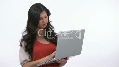 Woman using a laptop while holding it