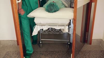Doctor and nurses wheeling a patient on his bed