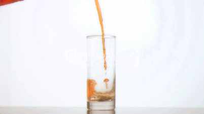 Orange fizzy flowing in super slow motion in a glass