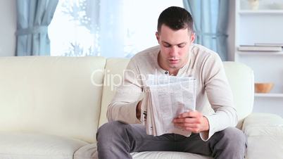 Man drinking a coffee while reading the news