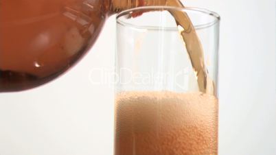Bottle filling in super slow motion a glass with fizzy drink