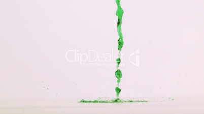 Green liquid flowing in super slow motion on a ground