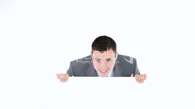 Businessman hiding beside a board