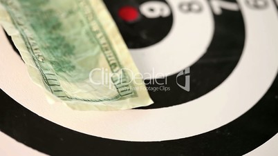 Dollar bills thrown on a spinning target
