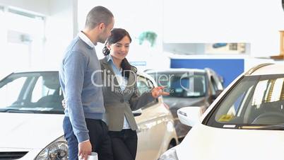 Stylish couple looking at a car