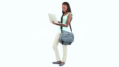 Woman standing with a bag and a laptop