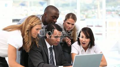 Happy business team looking at a computer