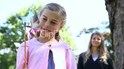 Woman and a girl playing with a pinwheel