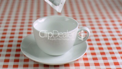 Tea bag falling in super slow motion in a cup