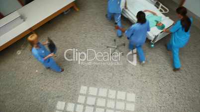 High angle view of a hospital team wheeling a patient on a bed