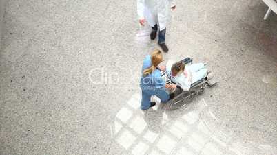 High angle view of a medical team wheeling a patient in a wheelchair