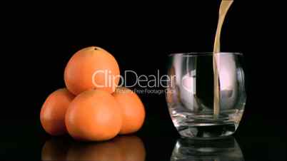 Fresh mandarin juice filling in super slow motion a glass