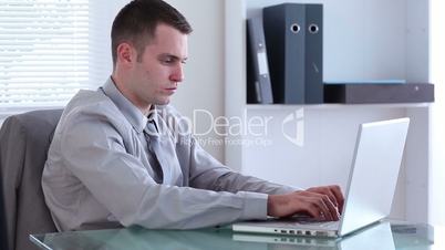 Depressed businessman working on a laptop