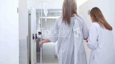 Patient with intravenous drip walking next to a doctor