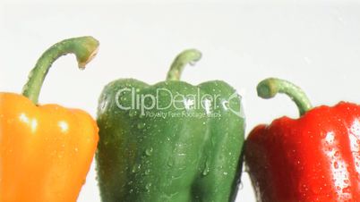 Colorful peppers in super slow motion being soaked