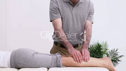 Physiotherapist massaging a calf of a patient