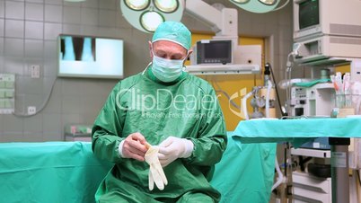 Surgeon putting on surgical gloves